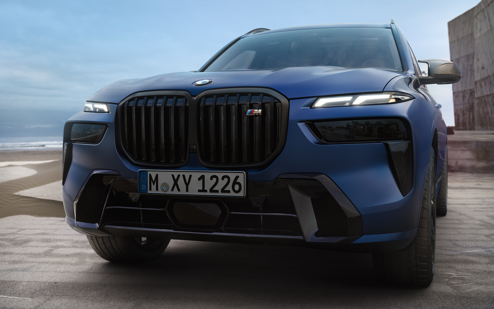 Prednji deo BMW X7 M60i xDrive G07 LCI Frozen Marina Bay plave boje bliži prikaz parkiranog vozila